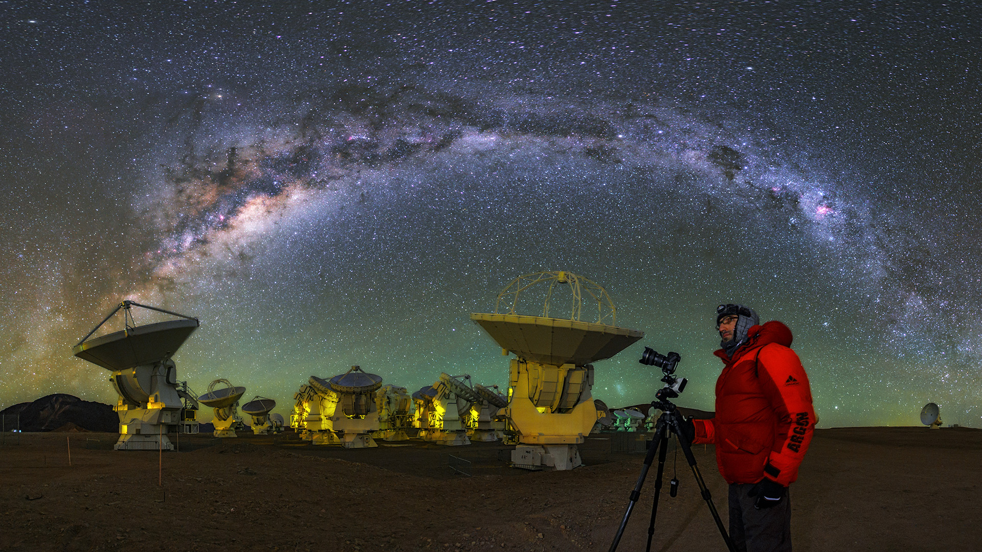 Högt uppe i Chile, på cirka 5000 meters höjd över havet, kan det bli extremt kallt vid Atacama Large Millimeter/submillimeter Array (ALMA). Här syns Babak Tafreshi, en av ESO:s fotoambassadörer, när han fångar den stjärnklara himlen. Vintergatan sträcker sig som en ljusbåge över honom.